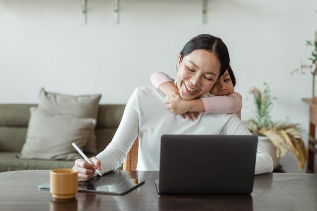 woman at laptop with child